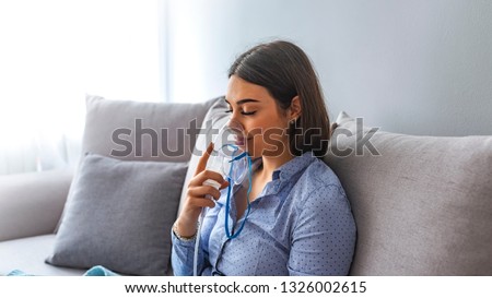 Woman makes inhalation nebulizer at home. Holding a mask nebulizer inhaling fumes spray the medication into your lungs sick patient. Self-treatment of the respiratory tract using inhalation nebulizer Royalty-Free Stock Photo #1326002615