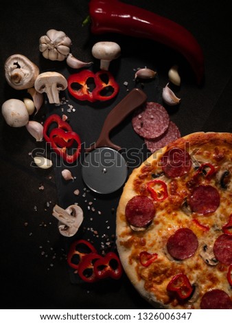 Traditional Italian pizza, vegetables, ingredients on a dark background. Pizza is cooking in the oven. Pizza menu.
