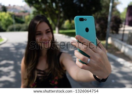 Girl taking selfie with smartphone blurred