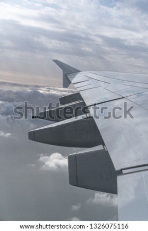 airplane wing over the clouds. plane wing with some clouds in the background