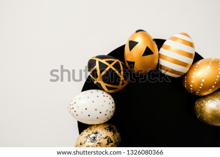 Stylish Easter golden decorated eggs on black plate isolated on white background. Trendy flat lay easter. Happy Easter card with copy space for text. Minimal easter concept
