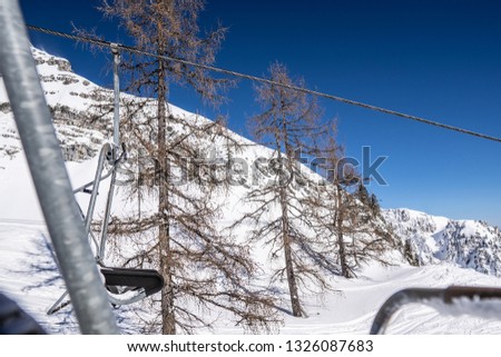 chair lift in an Austrian ski resort during winter. chair lift with snow and mountains in the background. Austrian ski resort photography.