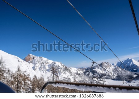 chair lift in an Austrian ski resort during winter. chair lift with snow and mountains in the background. Austrian ski resort photography.
