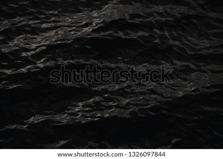 Beautiful waves creating interesting pattern on the surface of dark water.