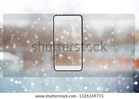 Transparent smartphone with a broken screen on the background of the windows.