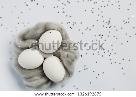Easter. Easter eggs in a gray nest. Silver. Bokeh.
