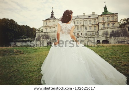 Wedding day. Gorgeous  bride walking next to castle in west Ukraine. Royalty-Free Stock Photo #132621617