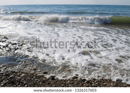 Surf on the gentle coast of the Black Sea in Abkhazia with light wind