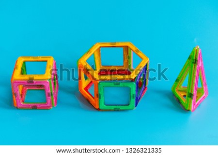 Children's bright color magnetic constructor on blue background. intellectual toy