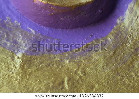 Concrete wall background in gold and purple.
