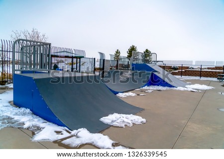 Skateboard ramps and melting snow on a skate park