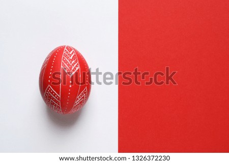 Creative red painted Easter egg on color background, top view. Space for text