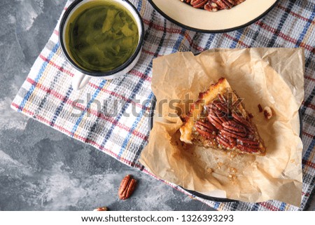 Tasty pecan pie with herbal tea on grey table
