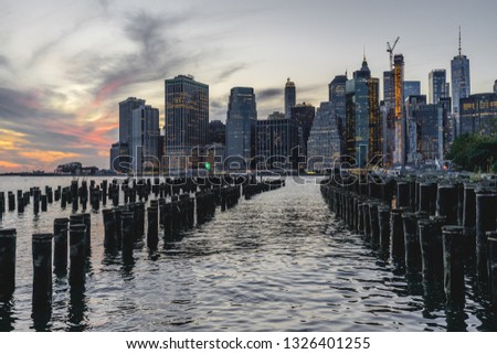Lower Manhattan skyline scenic view from Brooklyn Bridge Park in New York City during sunset, East River side