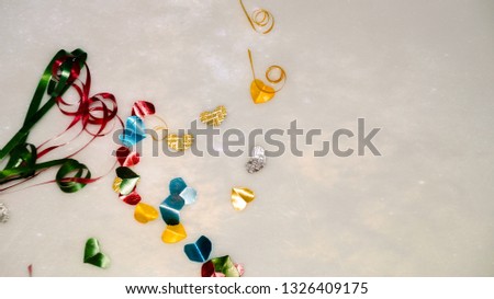 Colourful heart shape ribbon with small gift boxes on colorful bokeh, flare background.