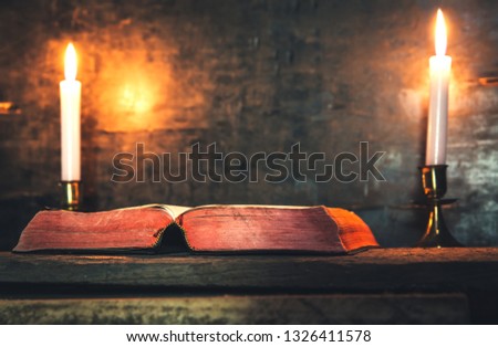 Holy bible with light of candle on wooden table at worship room. christian concept.