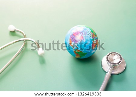 Stethoscope and globe on green background. Save the wold, Global healthcare and Green Earth day concept.