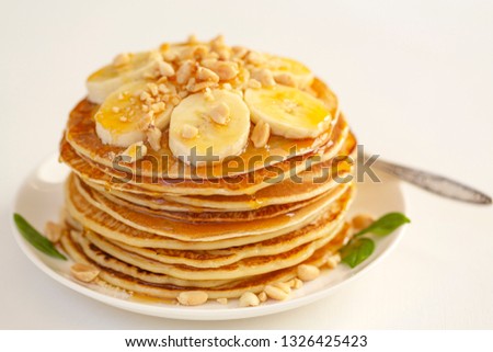 Sweet Homemade Stack of Pancakes with banana, nuts and honey. Delicious breakfast.