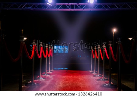 Red carpet with  barriers, velvet ropes and lights in the background Royalty-Free Stock Photo #1326426410