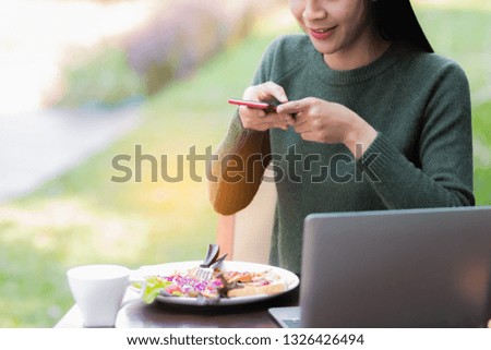 Asia woman,girl using laptop computer,smart phone take a photo food in free time with happy.