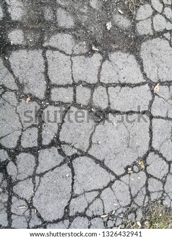 Gray asphalt in the cracks. Texture. Abstract background.