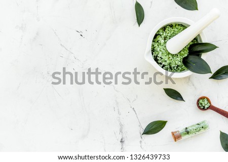 Make cosmetics with tea tree essential oil. Homemade cosmetics. Fresh tea tree leaves, mortar and pestel, cosmetics on white stone background top view border copy space Royalty-Free Stock Photo #1326439733
