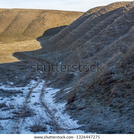 Dirt road on snow in spring as background .