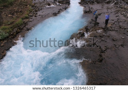 Photographers are trying to take pictures of the waterfall. Bruarafoss waterfall Iceland. Waterfall with clear blue water.
