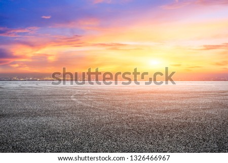 Empty asphalt square ground and city skyline with beautiful clouds at sunset