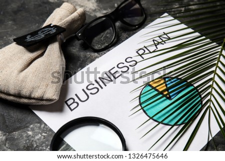 Sheet of paper with chart, eyeglasses and money bag on grey table. Concept of business planning