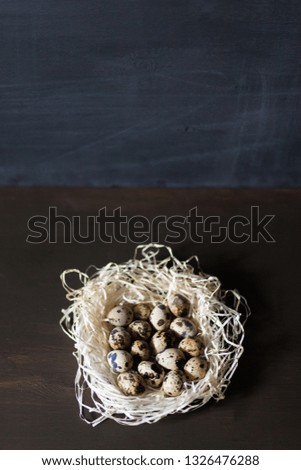 Quail eggs stacked in a pile or pyramid in a nest on a wooden background . for the Easter holiday . Easter background . new color and light for Easter photos and pictures