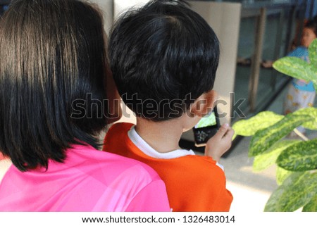 
The mother and son are taking pictures with the camera, shooting as a blur