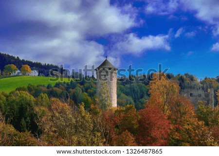 Old medieval castle tower on a hill in the forest in Europe on a bright sunny day.