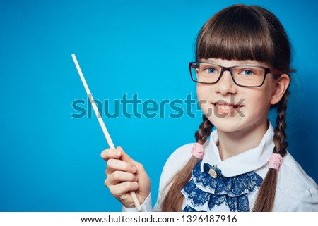 schoolgirl with glasses and a pointer on a blue background