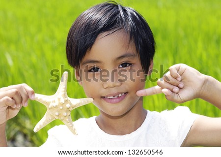 Little asian girl on rice fields green outdoor portrait