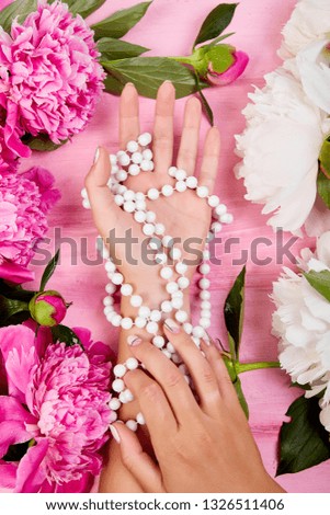 Florist at work. Hands of woman florist holding beautiful bouquet of peonies. Female making summer bouquet. Flat lay. Top view.