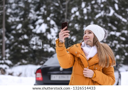 Young woman taking selfie at snowy winter resort