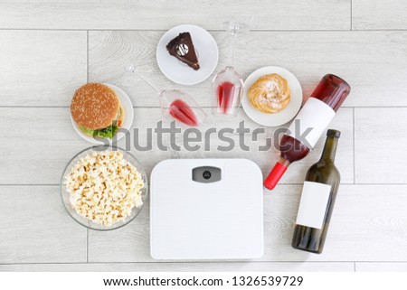 Flat lay composition with scales, different food and alcohol on floor. After party chaos