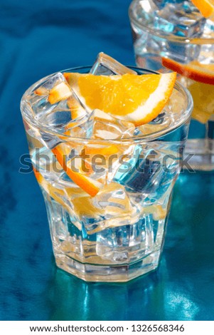 Summer mood, a glass of water and ice with orange slices