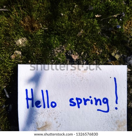 inscription on paper hello spring on nature background