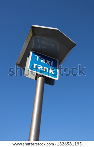 Peterlee / Great Britain - February 26, 2019: Taxi Rank sign on a tall metal pole with blue sky behind