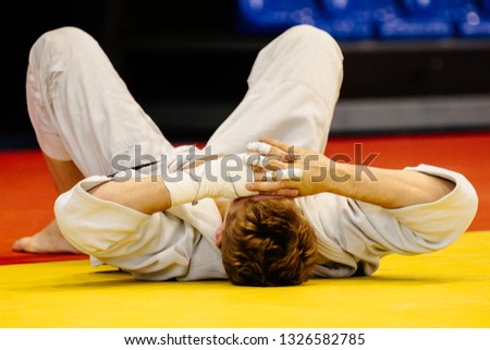 losing judoka in white kimono lie on your back in tatami