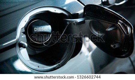 Diesel car concept. Open car fuel tank cap with the word diesel.