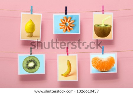 pictures with fruits hanging on a linen thread on stationery on clothespin on a colored background, concept of cheerful mood, design of home wall decor, photo frame, advertising of food business