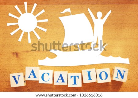 Summer Vacation at Seaside. Conceptual image with paper cuttings and wooden cubes on a desk