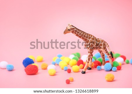 toy giraffe and colourful balls on pink background. Funny Holiday scene. creative minimal concept. festive composition. copy space.  