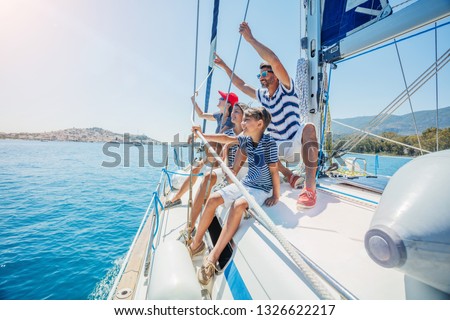Happy family with adorable daughter and son resting on a big yacht Royalty-Free Stock Photo #1326622217