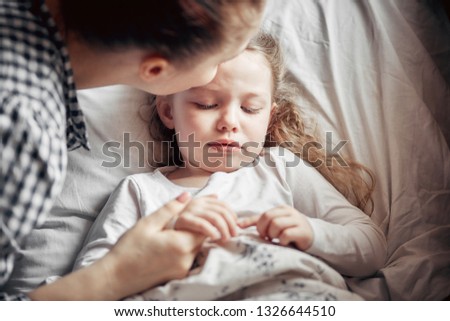 caring mother cut the nails of a little girl