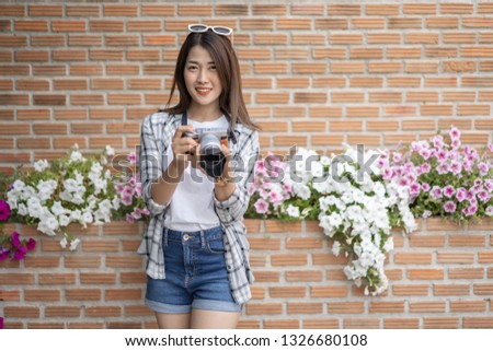 woman with mirrorless camera on brick wall background