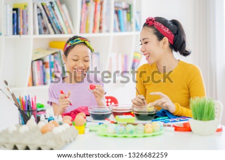 Picture of little girl dyeing eggs for Easter with her mother in the library